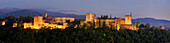 Panorama der Alhambra in der Dämmerung mit Bergen der Sierra Nevada im Hintergrund, Granada, Andalusien, Spanien