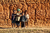 Children standing in front of a clay wall south of Antananarivo, Merina people, highlands, Madagascar, Africa
