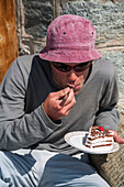 Man eating Black Forest cake, Turtmann hut, Turtmann valley, Canton of Valais, Switzerland