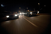 Two modern classic cars on the way at night, Motoraver group, Hamburg, Germany