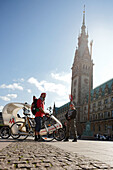 Trikshaw and bike courier on the town hall square, Hamburg, Germany
