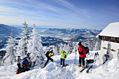Group of persons back-country skiing standing at the summit of Spitzstein, Inn valley and Mangfall range in the background, back-country skiing, Spitzstein, Chiemgau range, Tyrol, Austria