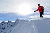 Backcountry skier standing on snow cornice, Sagtaler Spitzen, Kitzbuehel Alps, Tyrol, Austria