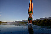Young woman jumping into the Lake Faaker, Alpe-Adria-Trail, Carinthia, Austria