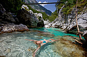 Young woman bathing in the river Soca, Alpe-Adria-Trail, Tolmin, Slovenia