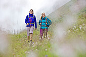 Zwei Wanderinnen gehen über eine Wiese, Alpe-Adria-Trail, Nockberge, Kärnten, Österreich