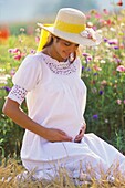Pregnant woman portrait in flower garden