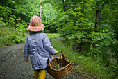 Little Girl in a Rain Coat and Rubber Boots with a Basket Walking down a Trail, Lake Muskoka, Bracebridge, Ontario