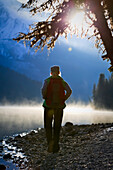 Woman hiking on misty fall morning, Maligne Lake, Jasper National Park, Alberta