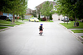 Little boy riding his bicycle on a suburban street, Markham, Ontario