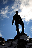 Silhouette of man standing on a mountain summit, Tombstone Territorial Park, Yukon