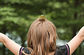 Frog sitting on the top of young girl's head, Ontario, Canada