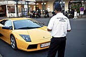 France, Provence, St Tropez, Marina, Policeman ticketing a yellow Ferrari