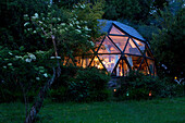 Geodesic dome by night in a private garden with an elderberry
