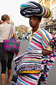 Rug Seller With Carpets Draped Over His Body In Mysore, Karnataka, India