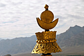Copper Tibetan Buddhist Victory Banner On The Roof Of The Thikse Monastery With Stok Mountain Range In Background