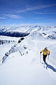 Female backcountry skier ascending to Vallatscha, Livigno Alps in background, Ofenpass, Grisons, Switzerland