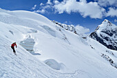 Female backcountry skier downhill skiing in front of Koenigspitze, Monte Cevedale, Ortler range, South Tyrol, Italy