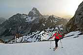 Female backcountry skier ascending to Hundstodgatterl, Watzmann in background, Berchtesgaden Alps, Berchtesgaden National Park, Upper Bavaria, Bavaria, Germany