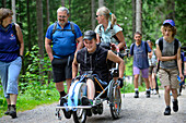 Group of hikers accompanying man in wheelchair, mountaineering with handicapped people, Rotwand, Spitzing, Bavarian Alps, Upper Bavaria, Bavaria, Germany