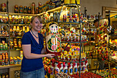 Young woman holding a giant Matryoshka doll for sale in a souvenir shop, St. Petersburg, Russia, Europe