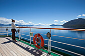 Junge Frau steht an Reling von Kreuzfahrtschiff MS Deutschland (Reederei Peter Deilmann), Chileniesche Fjorde, Patagonien, Argentinien, Südamerika