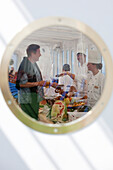 Cheerful chefs serving hearty delicacies during pre-lunch drinks on the the pool deck of cruise ship MS Deutschland (Reederei Peter Deilmann), South Pacific Ocean, near Chile