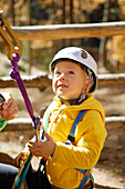 Junge mit Klettergurt am Seil im Hochseilgarten, Vernagt am See, Schnalstal, Südtirol, Italien