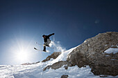Freerider springt über Felsklippe, Marmolata, Trentino, Italien