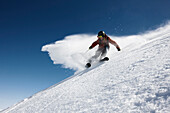 Man downhill skiing in deep snow, Marmolata, Trentino, Italy