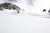 Man downhill skiing in deep snow, Grisons, Switzerland