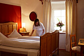 Housekeeping staff making bed in a hotel room, Karthaus, Schnalstal, South Tyrol, Alto Adige, Italy
