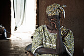Senior woman inside a mud hut, Yanfolila, Sikasso Region, Mali