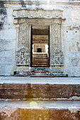 Reichlich in Stein geschnitzter Eingang zu einem Nebentempel von Ranakpur, Ranakpur, Rajasthan, Indien