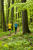 Young couple jogging in a beech forest, National Park Hainich, Thuringia, Germany