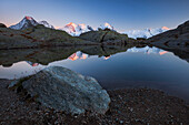 Alpenglühen auf Gipfel der Berninagruppe, Spiegelung in einem Bergsee oberhalb des Rosegtales, Engadin, Kanton Graubündne, Schweiz