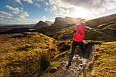 Junge Frau läuft über einen Wanderweg, Quiraing, Trotternish Halbinsel, Isle of Skye, Schottland, Großbritannien