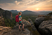 Junge Frau genießt den Sonnenuntergang, Nationalpark Sächsische Schweiz, Sachsen, Deutschland