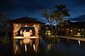 Family dining in the pavillion at Moevenpick Resort and Spa Mauritius at dusk, Bel Ombre, Savanne District, Mauritius