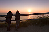 Couple looking from Dornbusch to the north over the Baltic Sea at sunset, Hiddensee island, Baltic Sea, Mecklenburg Western-Pomerania, Germany