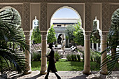 Woman walking through the arched passageway, Villa des Orangers, Marrakech, Morocco