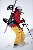 Junge Snowboarderin steigt durch den Schnee in den Bergen, Pitztal, Tirol, Österreich