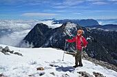 Frau steigt zum Hoher Göll auf, Dachstein und Tennengebirge im Hintergrund, Nationalpark Berchtesgaden, Berchtesgadener Alpen, Oberbayern, Bayern, Deutschland