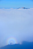 Silhouettes of two persons in fog, Brocken spectre, Kampenwand in background, Spitzstein, Chiemgau Alps, Upper Bavaria, Bavaria, Germany