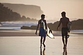 Two young surfers on Cotillo beach in Fuerteventura, Spain