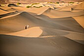 a couple walk on the sand dunes in Death Valley National Park, California, USA