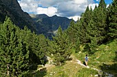 Hiker walking along Barrosa valley, a typical glacier valley of aragonese Pyrenees  Huesca  Spain