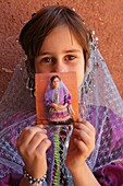 Portrait of a young iranian girl showing a Polaroid, Abyaneh, Iran