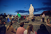 Evening mood with street artists and young people on the old Main bridge, Wuerzburg, Franconia, Bavaria, Germany