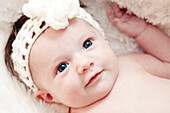 Newborn Baby With Knitted Headband Looking Up, Close Up, Portrait